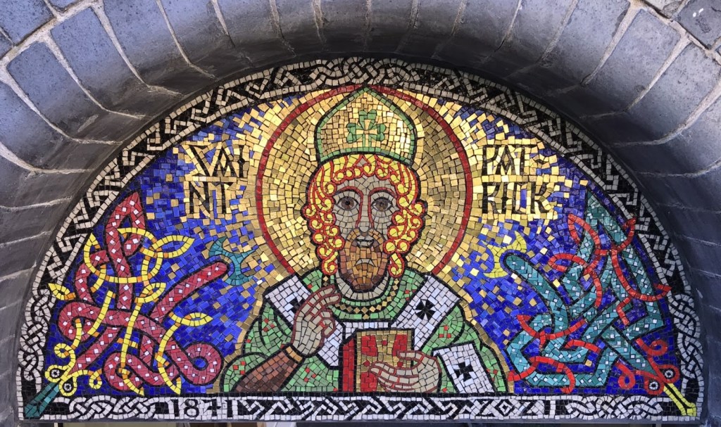 A mosaic of St Patrick with snakes and celtic key patterns